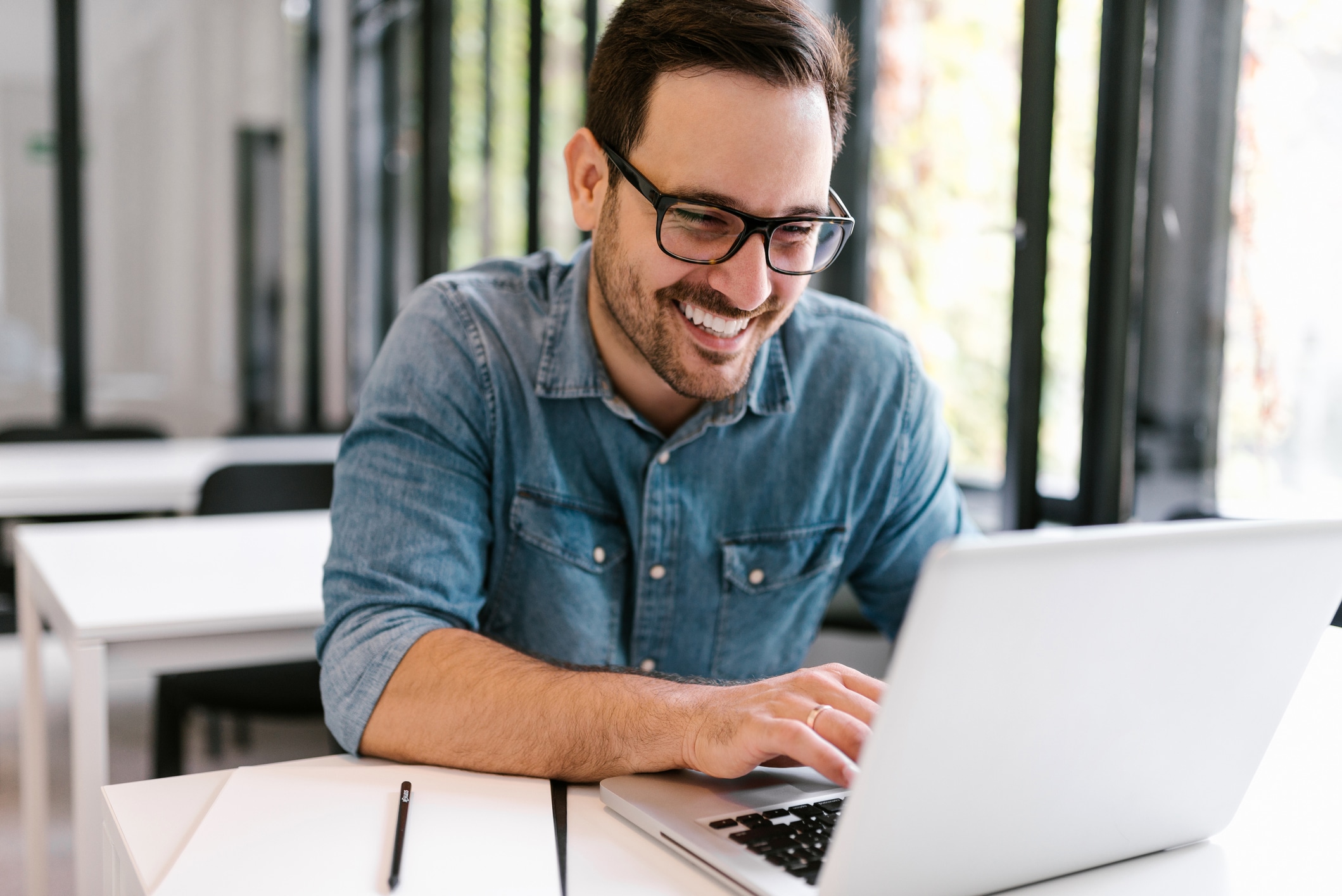 Happy young man using laptop. Close-up.