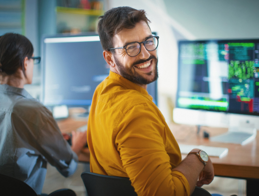 man with glasses at computer smiling man with glasses at computer smiling